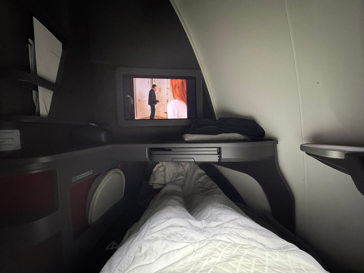 AA Flagship Suite Business Class watching TV from lie flat position