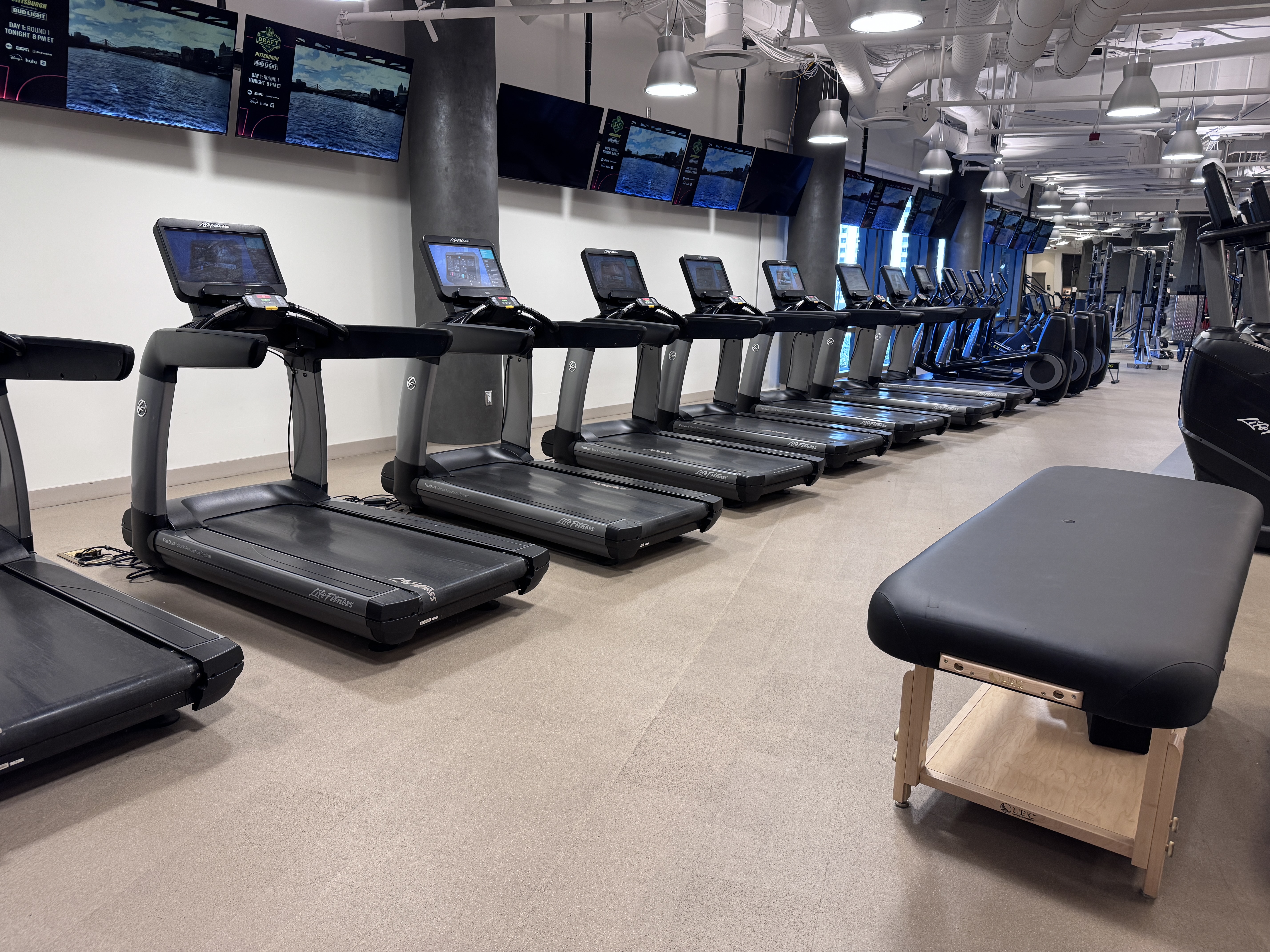 Resorts World Las Vegas gym row of treadmills with wall TVs