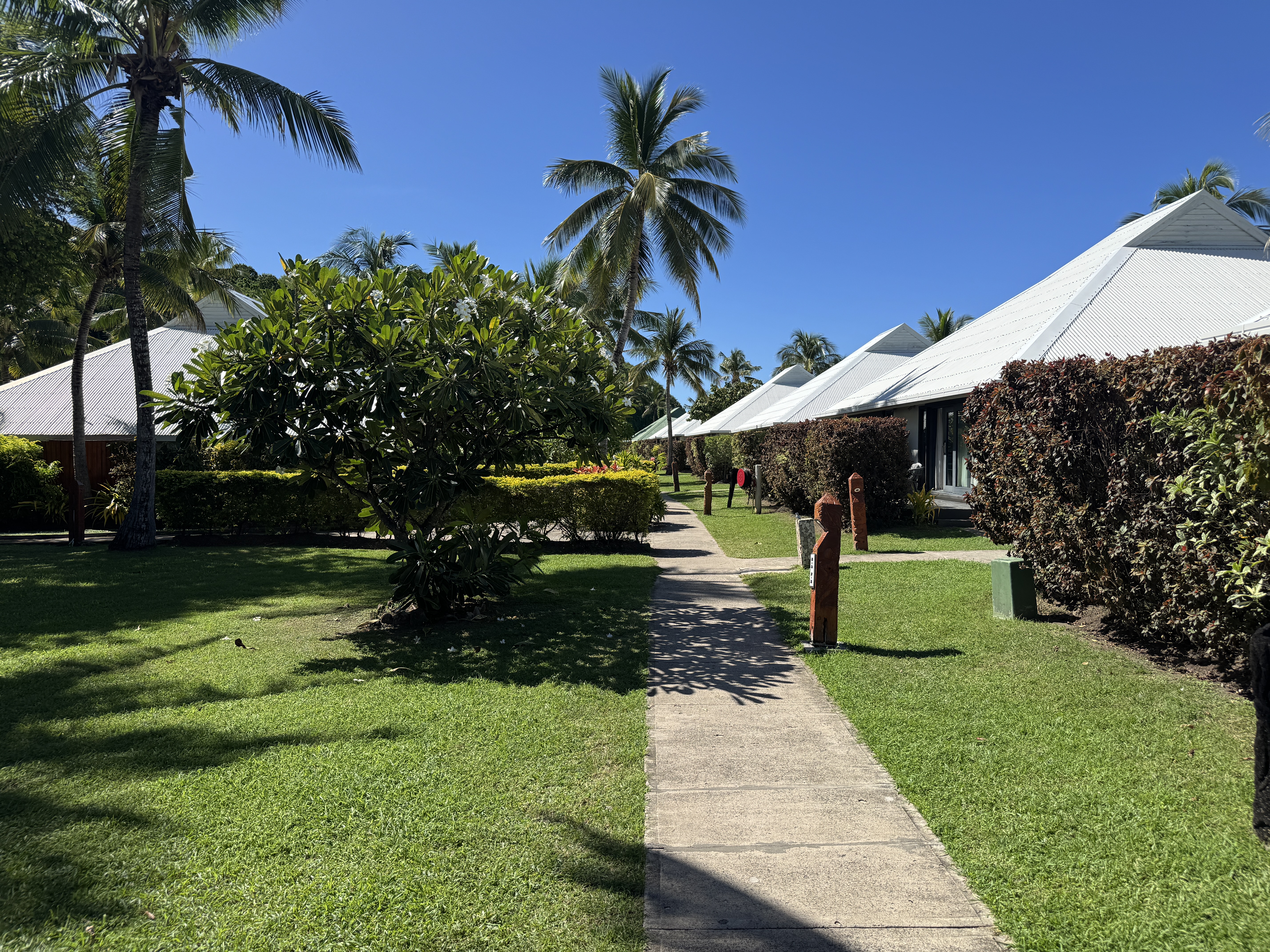 Sheraton Tokoriki Island Landscaped garden pathway between resort bungalows in sunshine